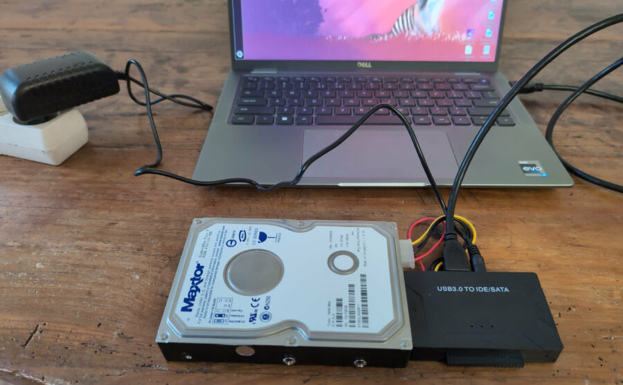 Un disque dur externe connecté à un ordinateur portable avec un câble PATA/IDE-USB.